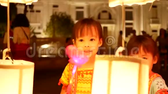 在清迈的易鹏节晚上亚洲小女孩站在泰国兰纳灯笼背景下的灯光下视频的预览图