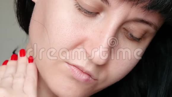 女孩用手触摸她的脸用扩张的毛孔检查皮肤护理问题皮肤的概念视频的预览图
