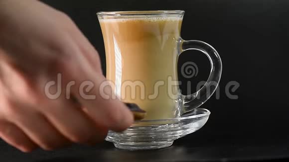带牛奶的茶或透明杯中的咖啡他们把饼干放在碟子上茶话会背景是黑色的视频的预览图