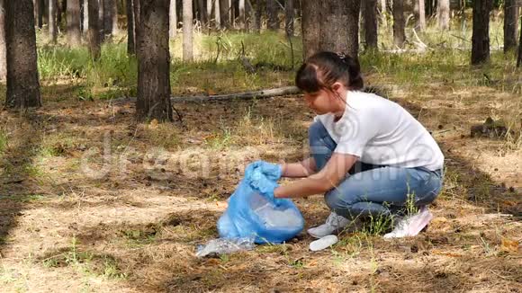 女孩志愿者照顾环境在树林里收集垃圾爱护环境的概念视频的预览图