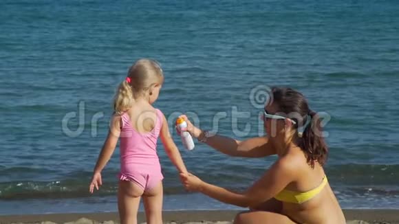 年轻女子在女儿身上涂防晒霜视频的预览图