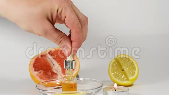 芳香油创造香水在灯光背景下柑橘口味柠檬葡萄柚手从地上滴下来视频的预览图