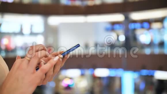 一个购物中心的女孩在电话里拨通一条信息把手举起来视频的预览图