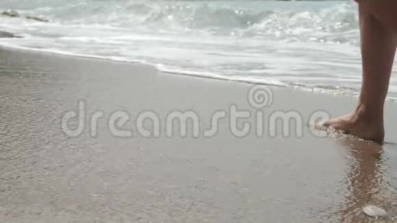 活跃的赤脚妇女走在沿海的沿海地带在沙滩上留下脚印视频的预览图