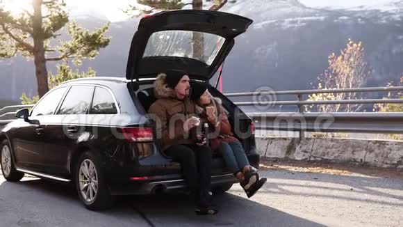 一对相爱的情侣在路上旅行男孩和女孩正坐在敞篷的车厢里吃三明治视频的预览图