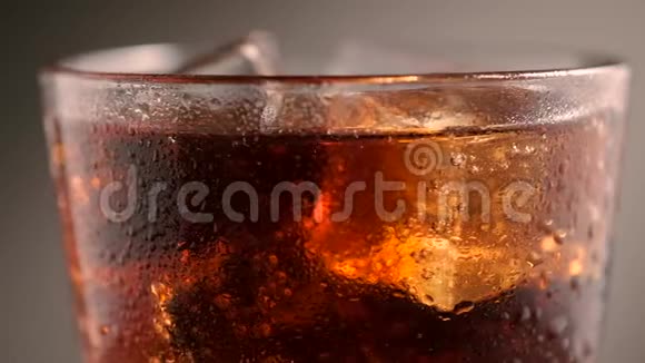 冰的杯子里的可乐绕着它的轴旋转视频的预览图