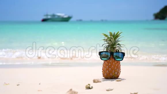 在烈日下海边的沙滩上摆放着菠萝眼镜为夏季树立了概念视频的预览图