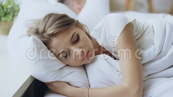 躺在床上沮丧的年轻女人在家里和男朋友在床上争吵后感到心烦意乱视频的预览图