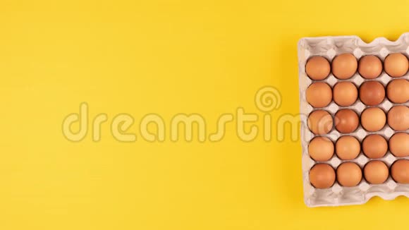 纸板箱里的鸡蛋消失在黄色的背景上视频的预览图