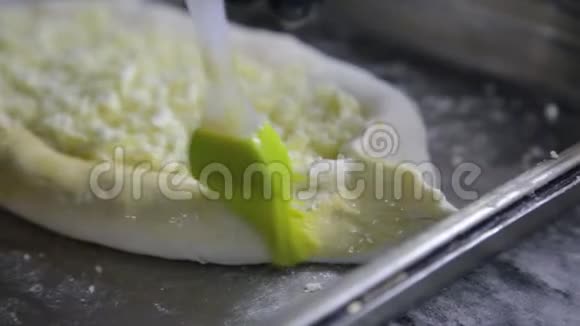 在烘烤前用蛋黄覆盖面团的特写手美味的格鲁吉亚美食视频的预览图