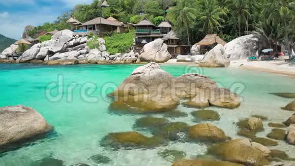 泰国Kohtao热带岛屿的豪华异国海滩上有花岗岩石块和棕榈树的蓝色海湾视频的预览图