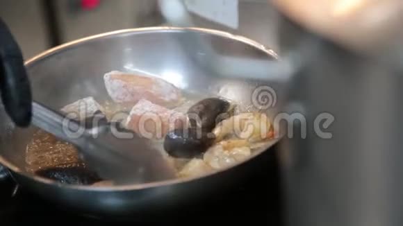 将虾虾贻贝和鱼放入煮沸的油中视频的预览图