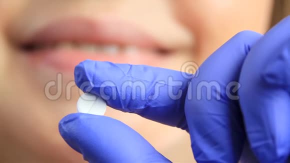 戴手套的医生手指里拿着一片白片慢镜头拍摄药理概念视频的预览图