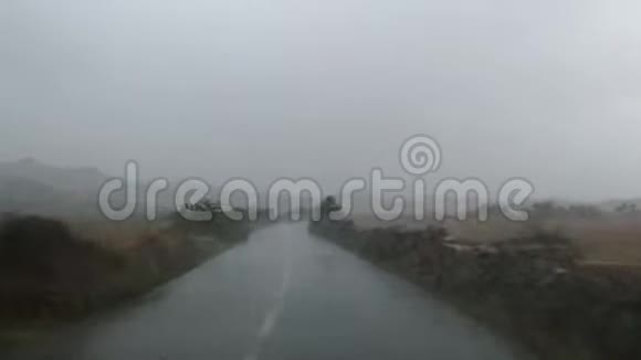 在大雨下驾驶在孤独的道路上视频的预览图