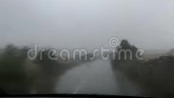 在大雨下驾驶在孤独的道路上时间流逝视频的预览图
