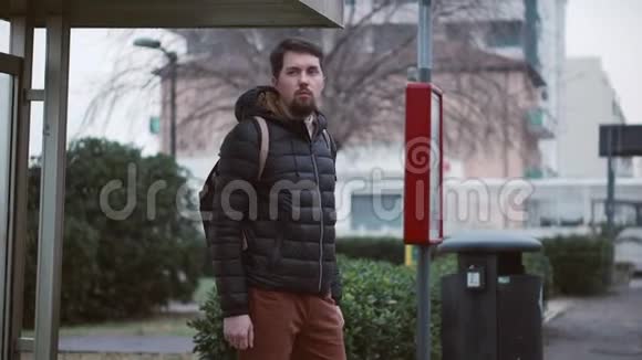 穿夹克的大胡子站在公共汽车站视频的预览图