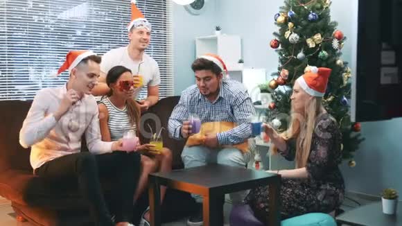 戴着圣诞帽戴着派对面具在欢乐的陪伴下庆祝新年快乐视频的预览图