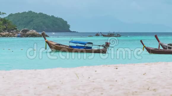 泰国KohLipe岛的长尾船在蓝水中摇摆前面是白沙滩等待游客视频的预览图