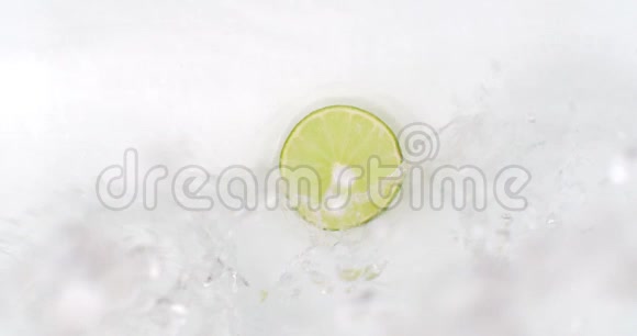 一个石灰躺在白色的背景上缓缓地落下溅起水花视频的预览图