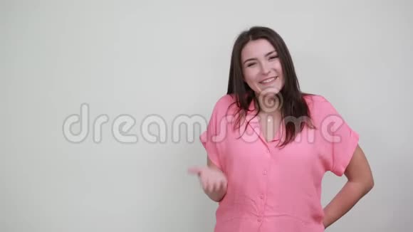 穿着粉红色衬衫的白种人年轻女子对着镜头握着拳头微笑着视频的预览图