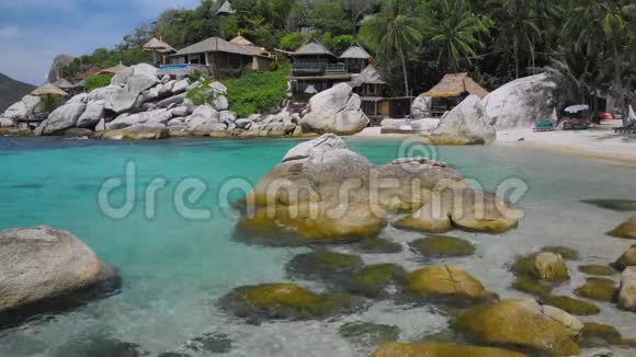 泰国Kohtao热带岛屿的豪华异国海滩上有花岗岩石块和棕榈树的蓝色海湾视频的预览图