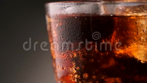 冰的杯子里的可乐绕着它的轴旋转视频的预览图