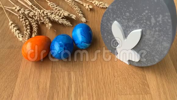彩色彩蛋在一张木桌上旋转背景是成熟的麦穗复活节的概念视频的预览图