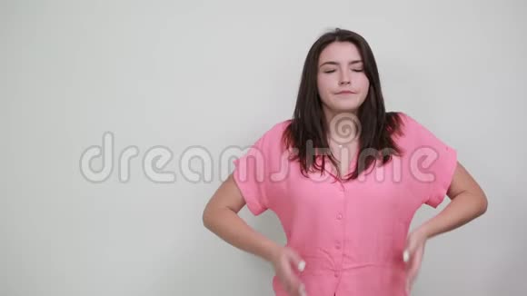 可爱的白种人年轻女子穿着粉红色的衬衫手挽着嘴打哈欠视频的预览图