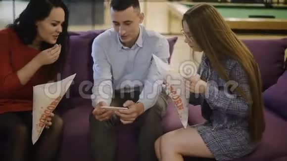 一群人一个男人和两个女孩看电影吃爆米花一群朋友学生们看着摄像机笑着视频的预览图