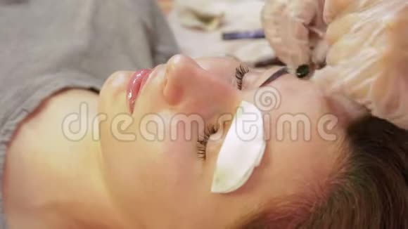 美容师从顾客的眉毛上清洗指甲花并涂上一种特殊的奶油视频的预览图