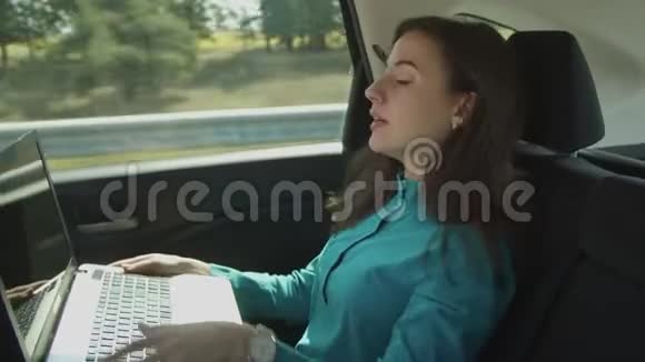 有笔记本电脑的女商人在车里打视频电话视频的预览图