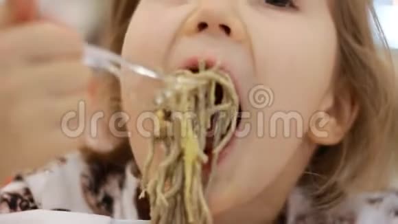 孩子吃有奶酪的意大利面小女孩在盒子里吃快餐面食视频的预览图
