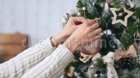把雌性手举起来挂在圣诞树树枝上的金球玩具4k龙红相机视频的预览图