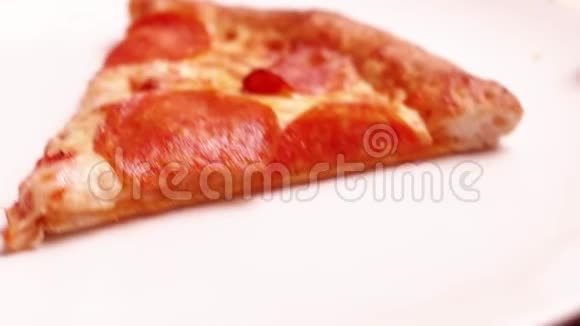 将美味的意大利辣香肠比萨饼片放入干净的白色盘子中视频的预览图