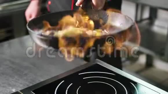 厨师在炒锅中煮蔬菜在燃烧的火焰中慢动作近距离拍摄4k红色相机视频的预览图