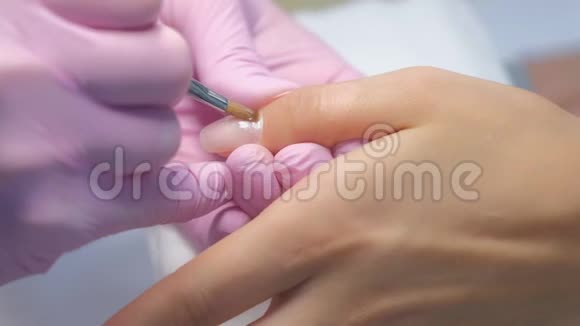 美甲大师是在美容诊所用刷子涂指甲凝胶紫胶视频的预览图