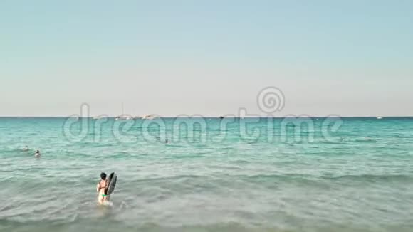 未被认出的女游客带着一个充气的游泳圈进入大海暑假概念反对视频的预览图