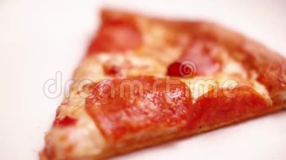刚从烤箱里拿出一个干净的白色盘子的意大利香肠披萨片视频的预览图