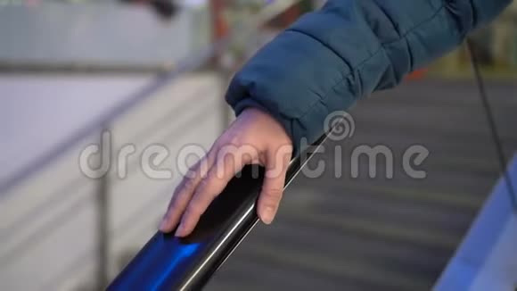 一个女人用手指轻敲玻璃扶梯的栏杆一个女人的手紧紧在一个女人的栏杆上视频的预览图
