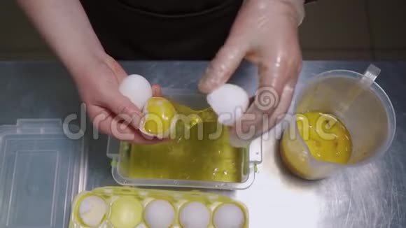 女性手拿着一个破裂的鸡蛋鸡蛋白和蛋黄的分离视频的预览图
