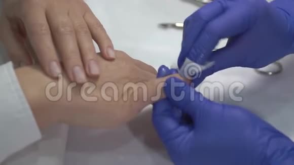 专业美甲师在手套清洁指甲前覆盖清漆视频的预览图