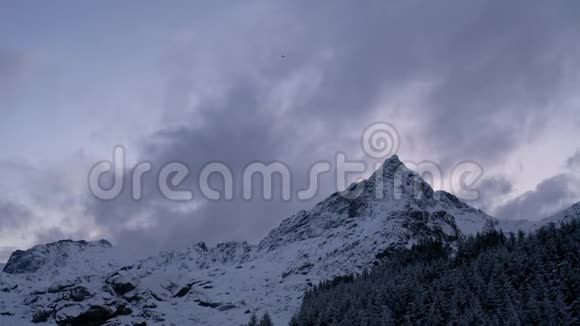 在挪威日落时雄鹰飞过陡峭的山峰冬季鸟瞰鹰视频的预览图