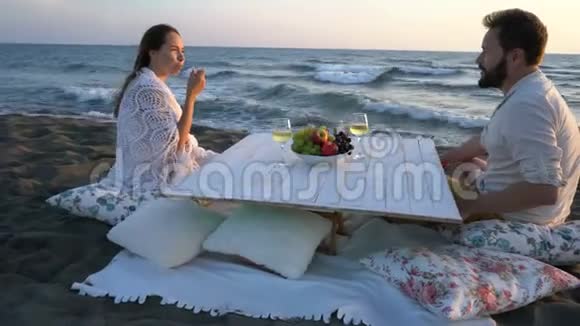 有魅力的一对夫妇在海边葡萄酒和水果在的公司里享受视频的预览图