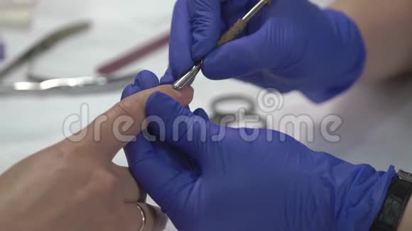 专业的美甲师在手套准备指甲皮肤之前覆盖清漆视频的预览图
