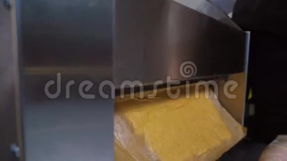 做面团片在一台特殊的烹饪机器上滚动面团特写视频的预览图