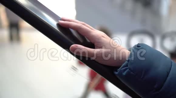 一个女人的手一个移动扶梯的栏杆上一个女人骑着车在栏杆上轻敲手指视频的预览图
