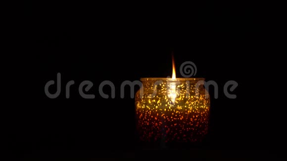烛台上的蜡烛在黑色背景下燃烧视频的预览图