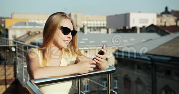 屋顶露台上带智能手机的女士视频的预览图