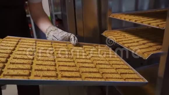 厨师把一个带有长方形饼干的烤盘放在一个特殊的架子上视频的预览图