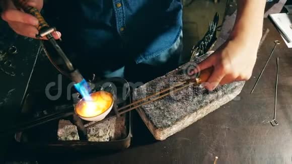 戴戒指的珠宝匠珠宝商用燃烧器熔化金属视频的预览图